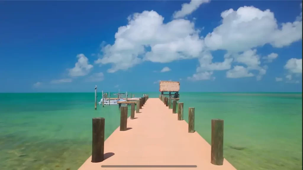 Pier de madeira sobre o mar azul-esverdeado nas Florida Keys em um dia ensolarado com céu azul e nuvens brancas.